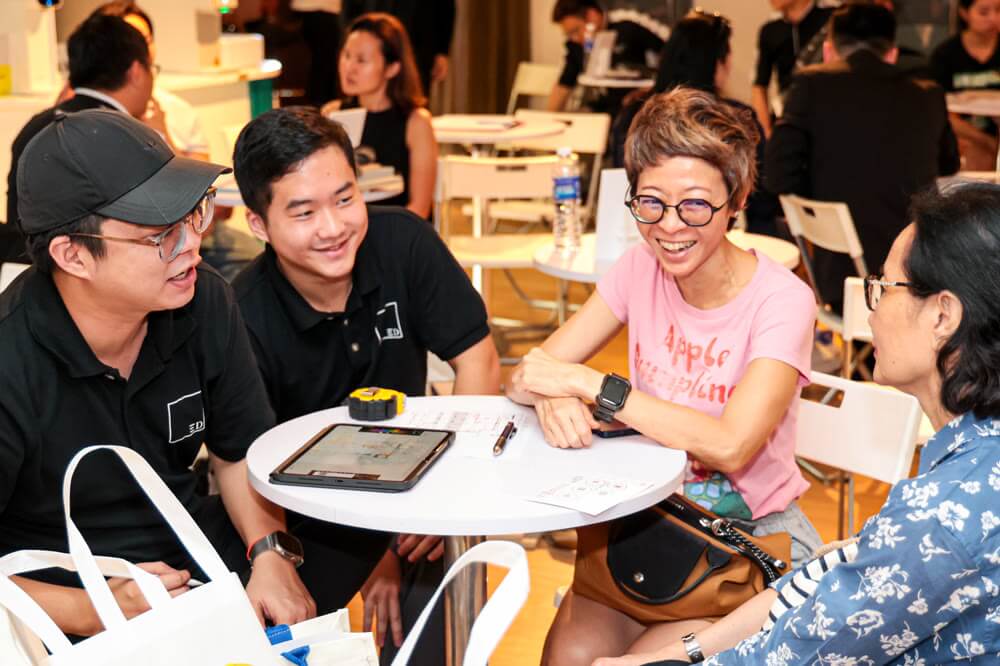 Homeowners laughing with designers at a consult table